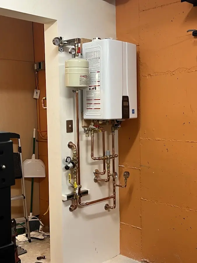 Plumbing technician inspecting water heater connections in Minneapolis
